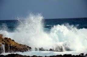 ocean spray on rocks on a sunny day