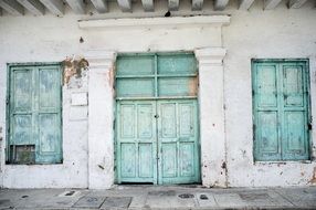 facade of an old building with turquoise doors