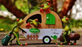ceramic frogs in travel caravan on blurred background with the plants