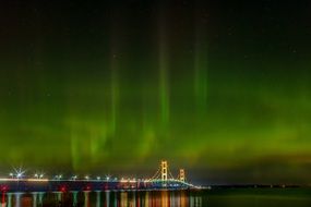 northern lights over a bright bridge in michigan
