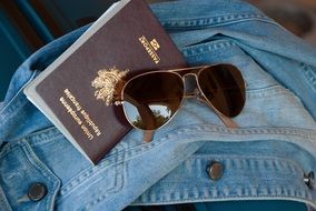 passport , glasses and denim jacket
