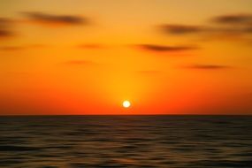 bright sun and yellow-orange sky over the ocean