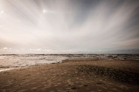 sandy beach near the Baltic Sea under the sky with white clouds