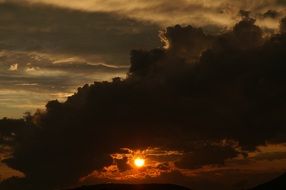 bright setting sun in black clouds