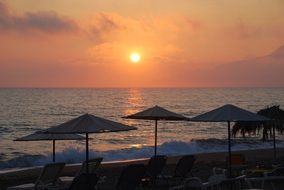 sunset on the beach in crete in the evening with silhouettes on the shore