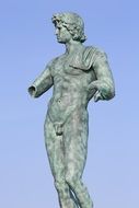 Antique statue of Adonis on blue sky background