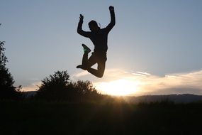 young man jump against the evening sky