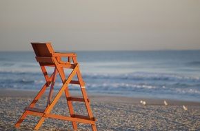 Orange chair of the life guard near the ocean beach