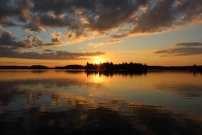 orange sunset over a forest lake