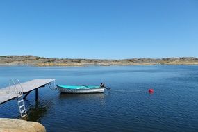 boat near a wooden pier on a clear sunny day