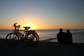 couple near bicycles at romantic sunset, gran canaria