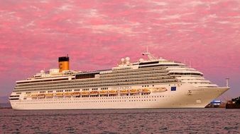 Landscape of cruise liner on a background of pink sunset