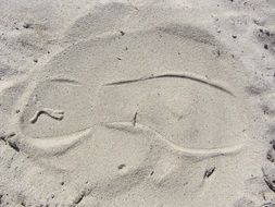 footprint of shoes on a sandy beach closeup