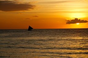 silhouette of a sailboat on the horizon at sunset