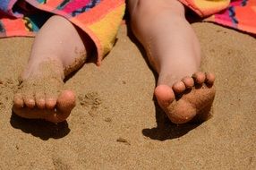 feet of a man lying on the beach