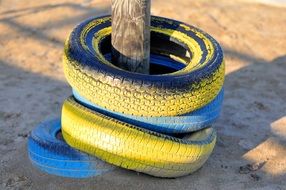 multi-colored tires on a wooden pillar