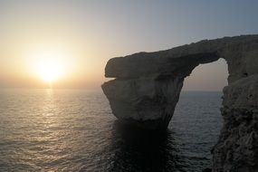 stone arch at sea during sunset