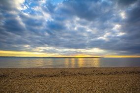sunset on the horizon of the ocean behind the clouds