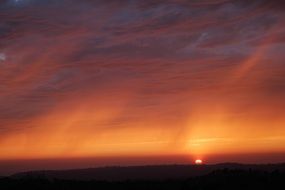 Beautiful and colorful sunset above the landscape with silhouettes