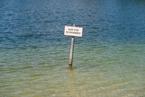 Warning Sign on pole in water