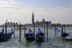 covered Gondolas parked on Channel in view of city, italy, Venice