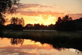 distant view of fog over a meadow at sunset