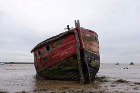 Wreck of the colorful boat on the beach