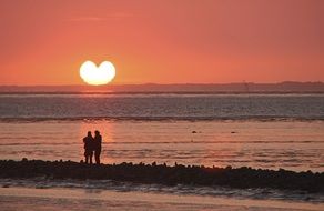 Heart shape sun setting at horizon, romantic Sunset