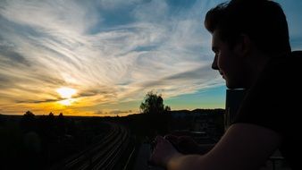 young man thinks about the future at sunset