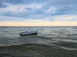 lonely white boat in the ocean offshore