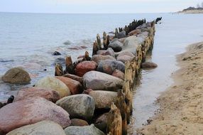 scenic aged breakwater on coast of Baltic Sea