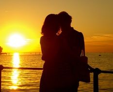 people kissing in the sunset