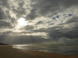 sunbeams in gray clouds over the Belgian coast