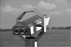 black and white photo of a telescope for tourists