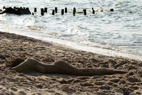 sand mermaid on the beach near the water