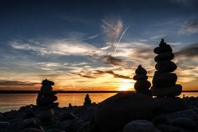 Stacked stones on a beach at the sunset