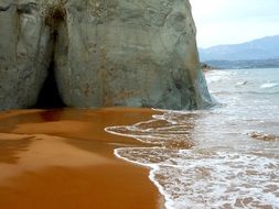 waves on the beach near the cliff