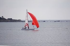 sailboat with a bright red sail