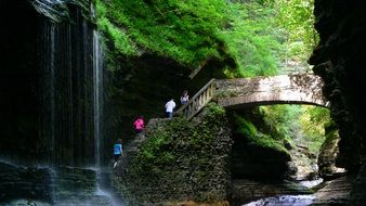 tourists on a bridge over waterfalls in watkins glen