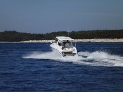 distant view of a yacht in spray