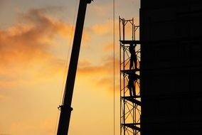 Working people on a construction at the sunset