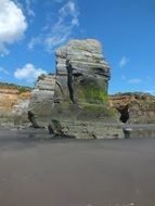 Beautiful Three Sisters rock in moss on the sandy beach in New Plymouth