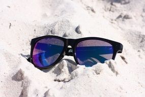 Sunglasses on white sand