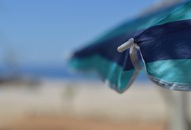blue umbrella on the beach on a summer day