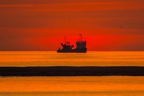 cargo ship on a background of red sunset in England