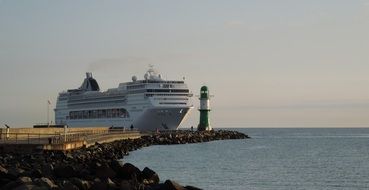 lighthouse on the background of a cruise ship