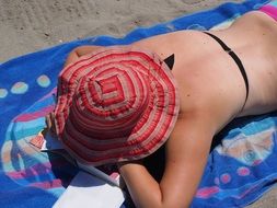 sunbathing woman lying on the bathtowel