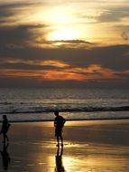 people on a sandy beach at sunset on bali