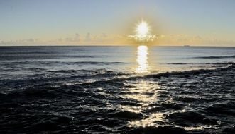 sun rays on the ocean during sunset