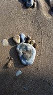 stones in the shape of a man’s footprint on a beach in Italy